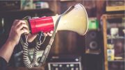 person holding red and white megaphone